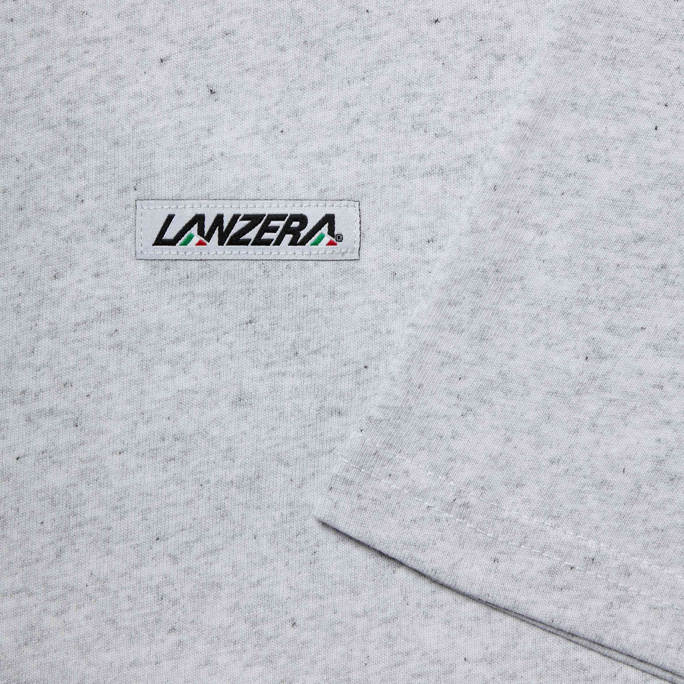 Close-up of the Lanzera logo patch on the Heather Club Tee. The signature Lanzera branding is stitched onto the soft, heathered fabric, adding a subtle yet stylish detail to the t-shirt.