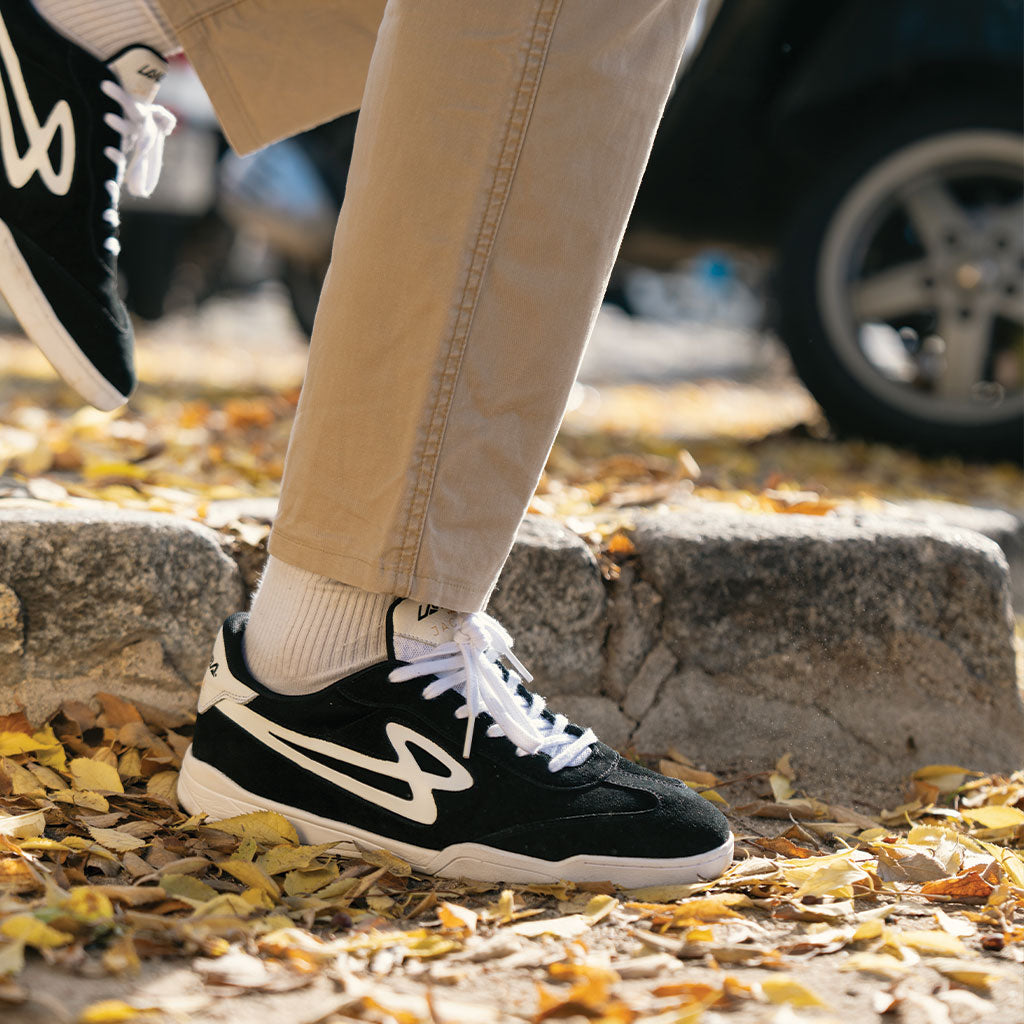 Lanzera Jackal black suede sneakers styled casually with khaki pants, highlighting the sleek, everyday wear design inspired by classic football culture.